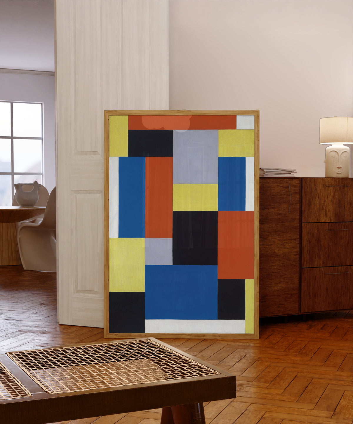 Framed art print of Composition XX by Theo van Doesburg, in a light wood frame leaning in a warm room with a parquet floor