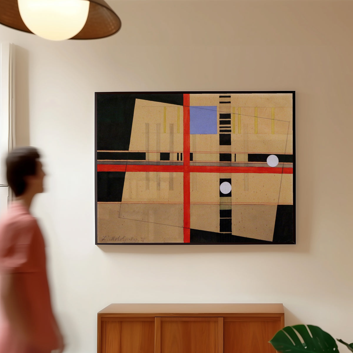 Framed art print of Croce rossa e palle bianche by László Moholy-Nagy, in a slim black frame on a warm wall in a sunlit room