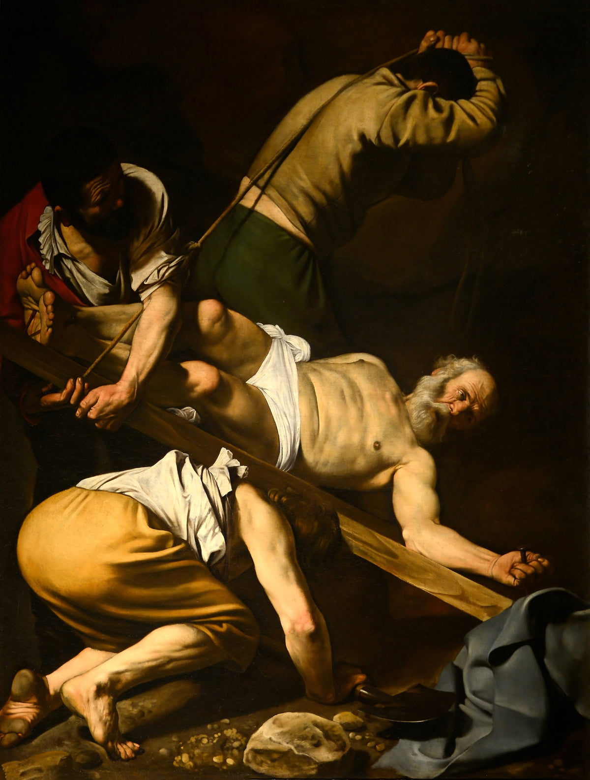 Crucifixion of St. Peter by Caravaggio — A bearded saint lies on a cross as three men raise it