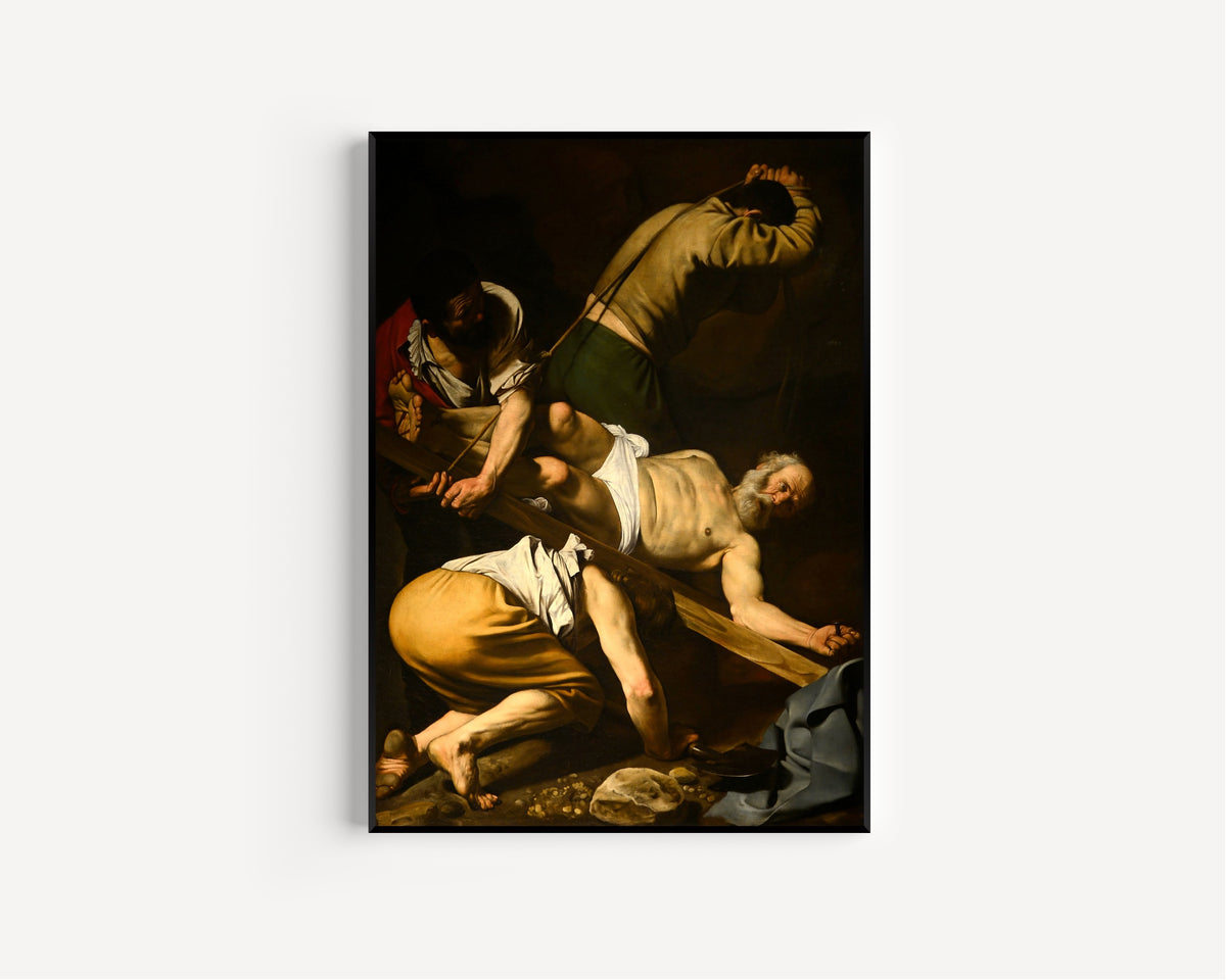 Framed art print of Crucifixion of St. Peter by Caravaggio, in a slim black frame on a plain white wall