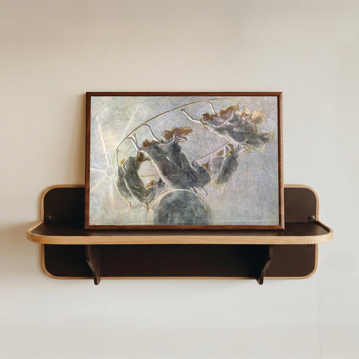 Framed art print of Dance of the Hours by Gaetano Previati, in a dark wood frame resting on a wall shelf