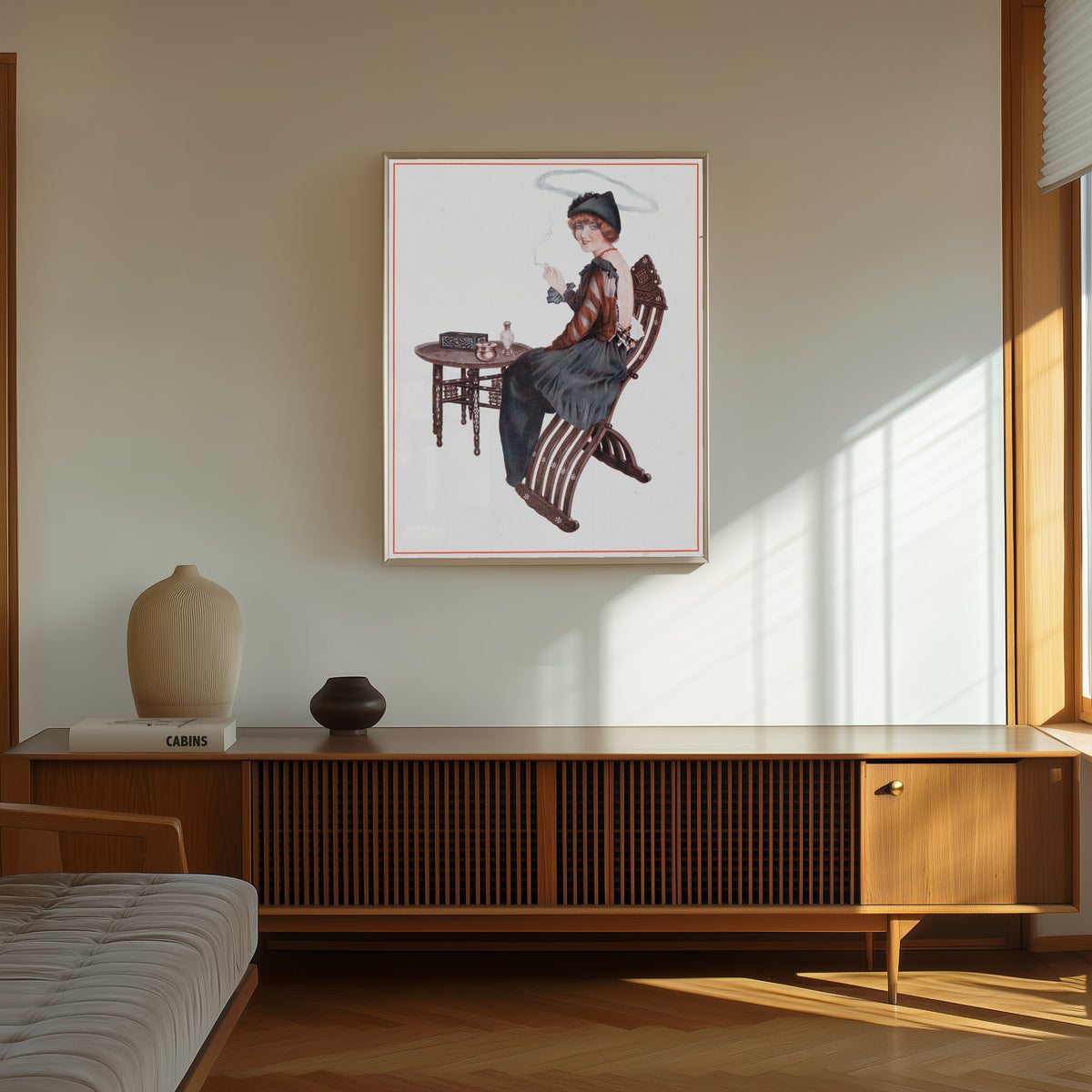 Framed art print of De la Brune à la Blonde, Pl. 4: L'Auréole de Sainte… by Raphael Kirchner, in a thin light frame on a sunlit wall above a wooden sideboard