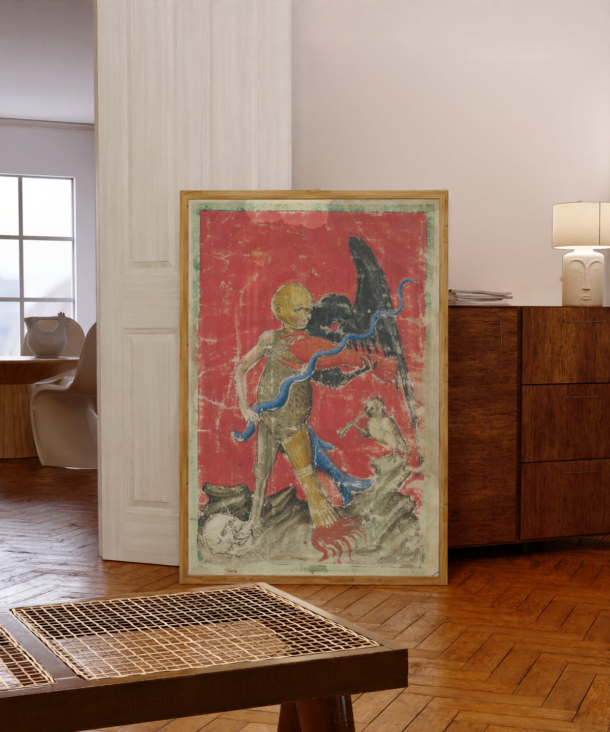 Framed art print of Death with a Serpent and an Eagle (Aurora Consurgens) by Unknown artist, in a light wood frame leaning in a warm room with a parquet floor
