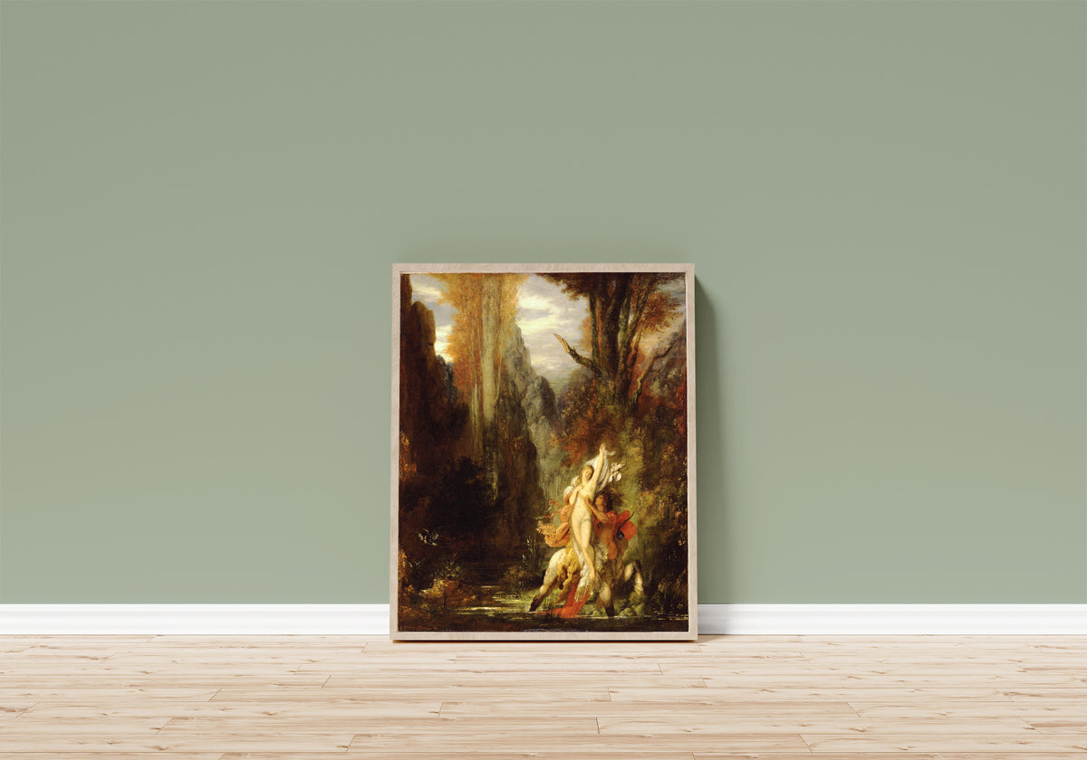 Framed art print of Dejanira by Gustave Moreau, in a light wood frame leaning on a sage green wall above a wooden floor