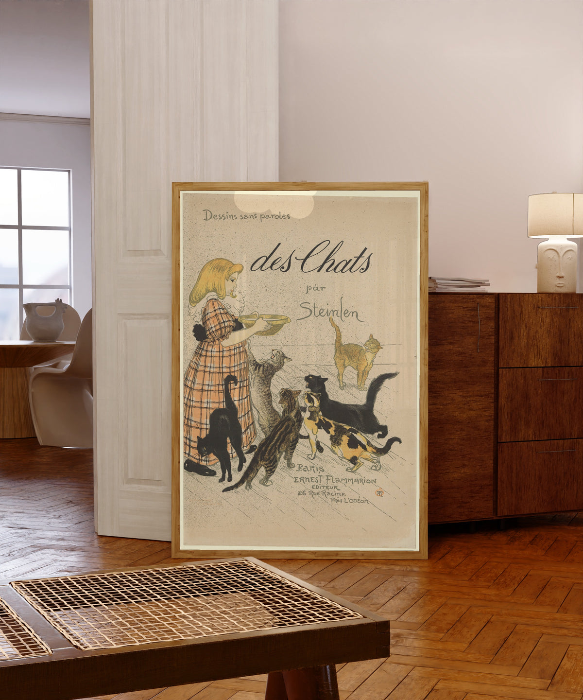 Framed art print of Des chats, par Steinlen (cover) by Théophile Steinlen, in a light wood frame leaning in a warm room with a parquet floor