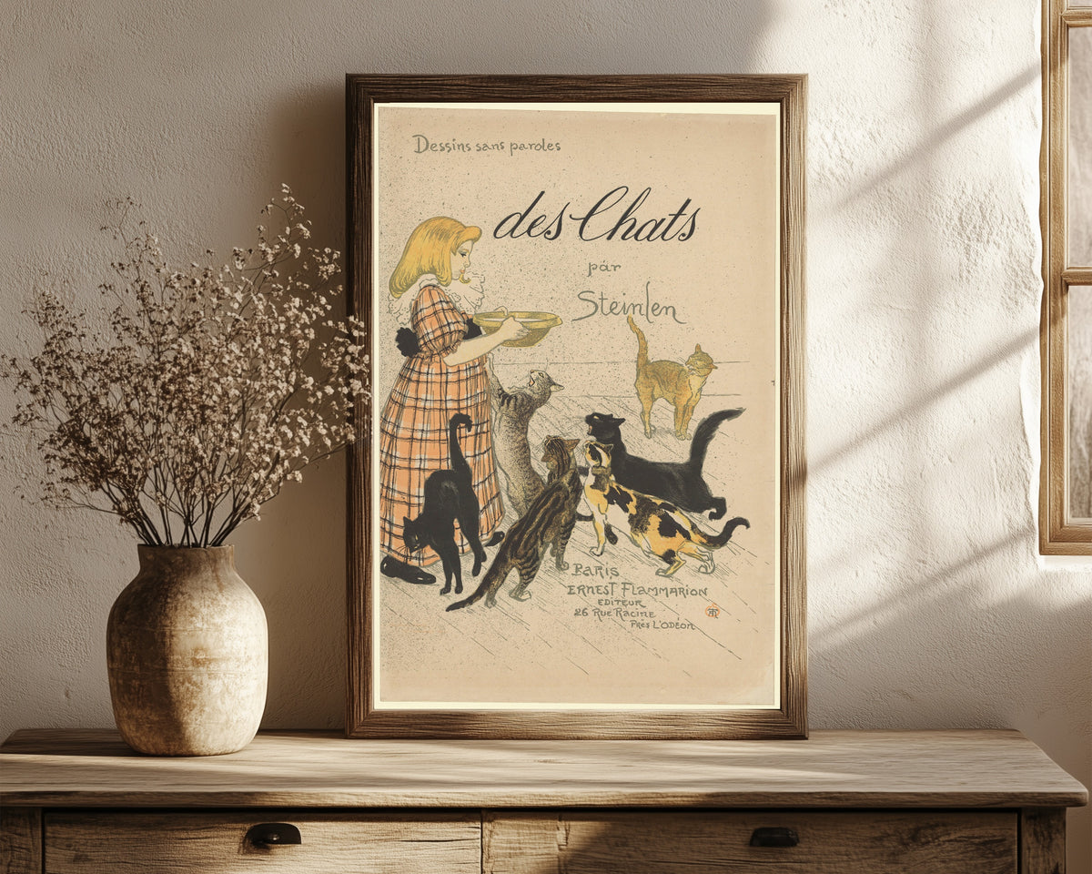 Framed art print of Des chats, par Steinlen (cover) by Théophile Steinlen, in a dark wood frame leaning on a rustic console beside dried flowers