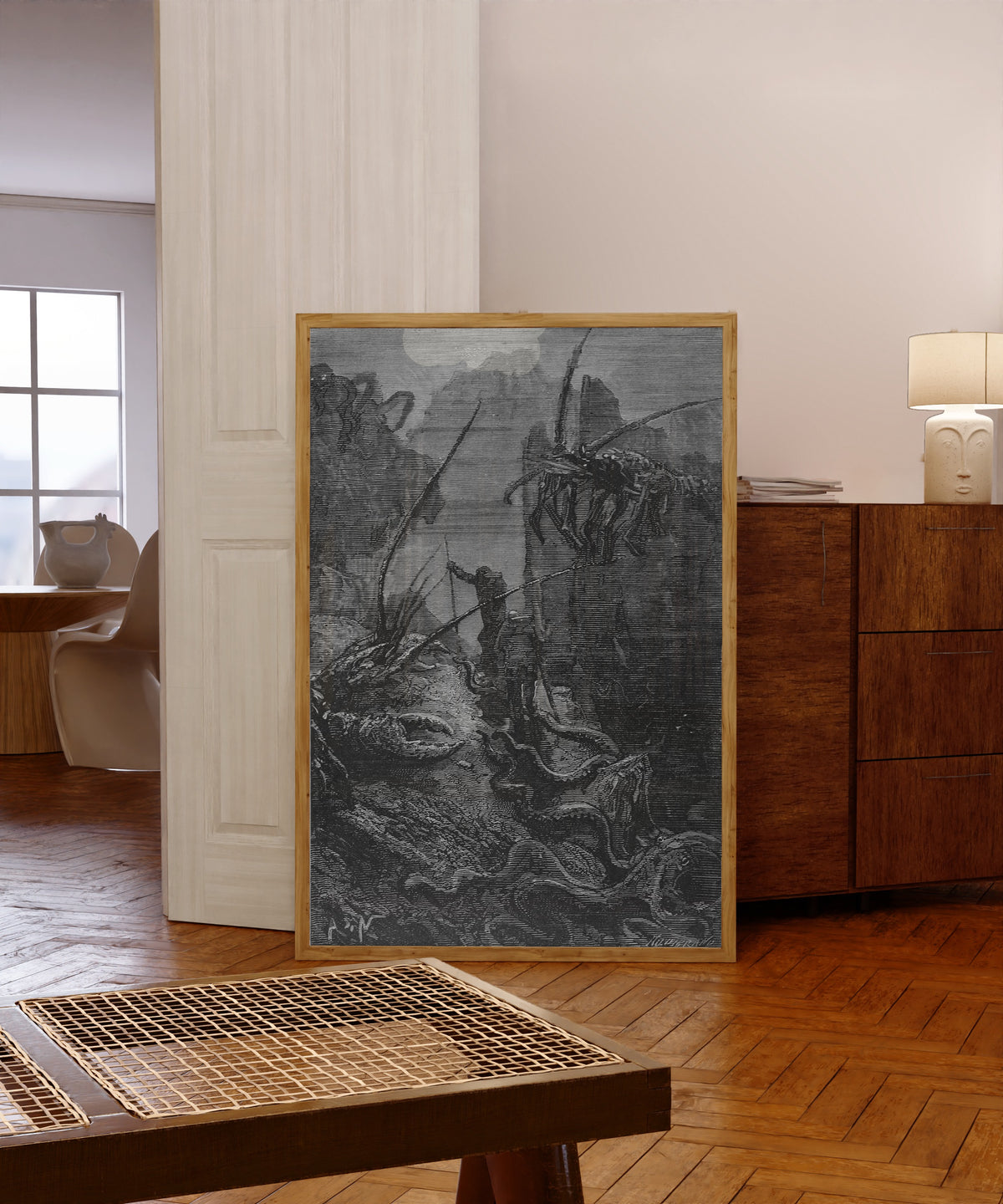 Framed art print of Des homards géants, des crabes titanesques… by Alphonse de Neuville, in a light wood frame leaning in a warm room with a parquet floor