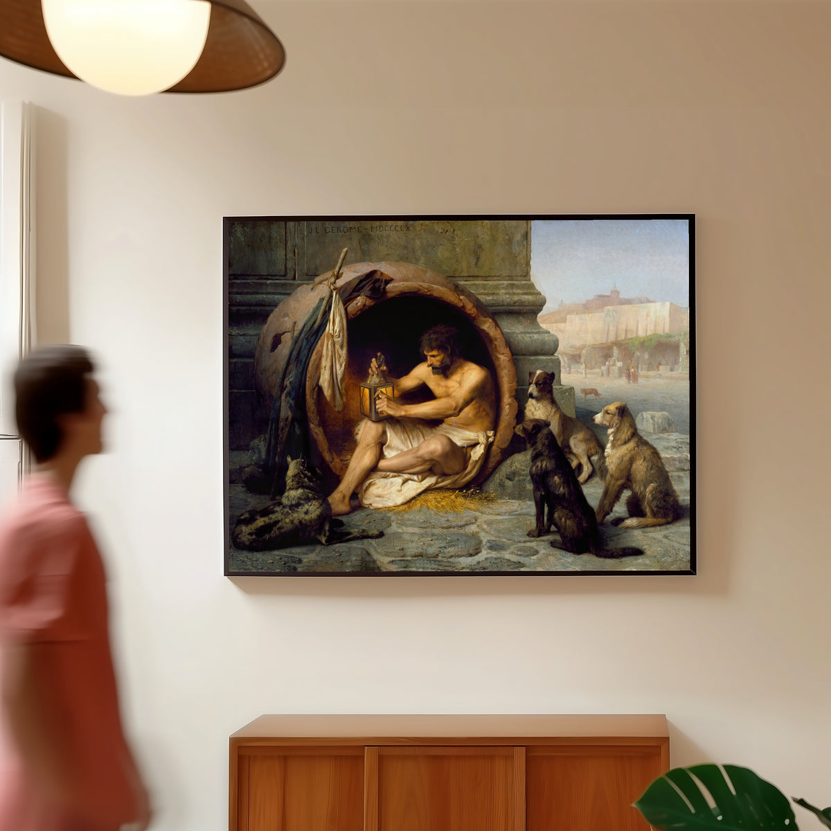Framed art print of Diogenes by Jean-Léon Gérôme, in a slim black frame on a warm wall in a sunlit room