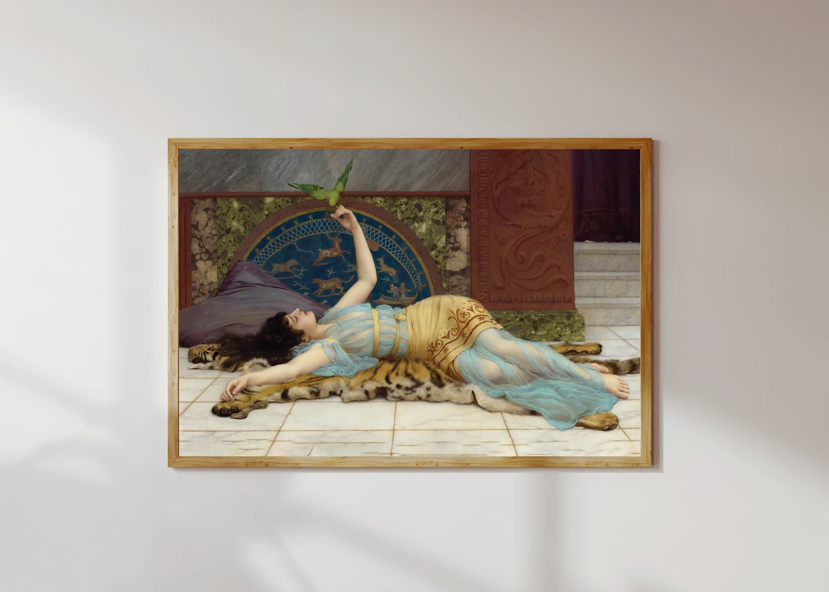 Framed art print of Dolce Far Niente by John William Godward, in a light wood frame on a sunlit white wall