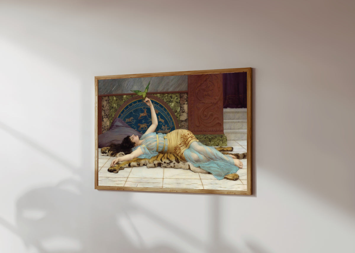 Framed art print of Dolce Far Niente by John William Godward, in a light wood frame on a sunlit white wall, seen at a slight angle