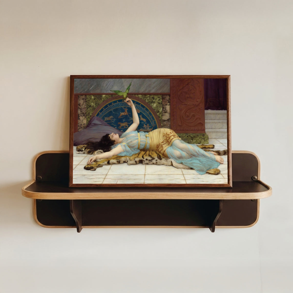 Framed art print of Dolce Far Niente by John William Godward, in a dark wood frame resting on a wall shelf