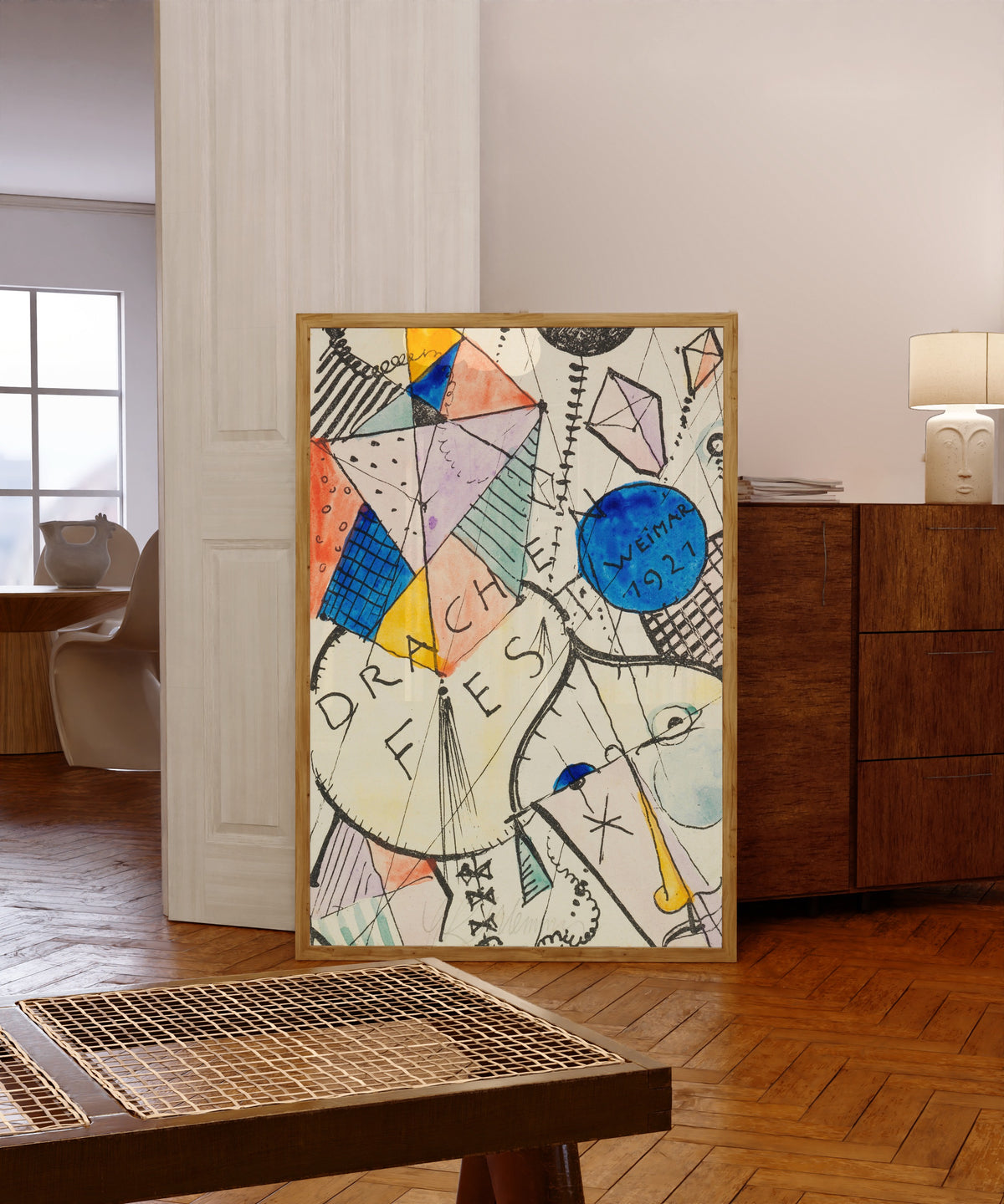 Framed art print of Drachenfest by Oskar Schlemmer, in a light wood frame leaning in a warm room with a parquet floor