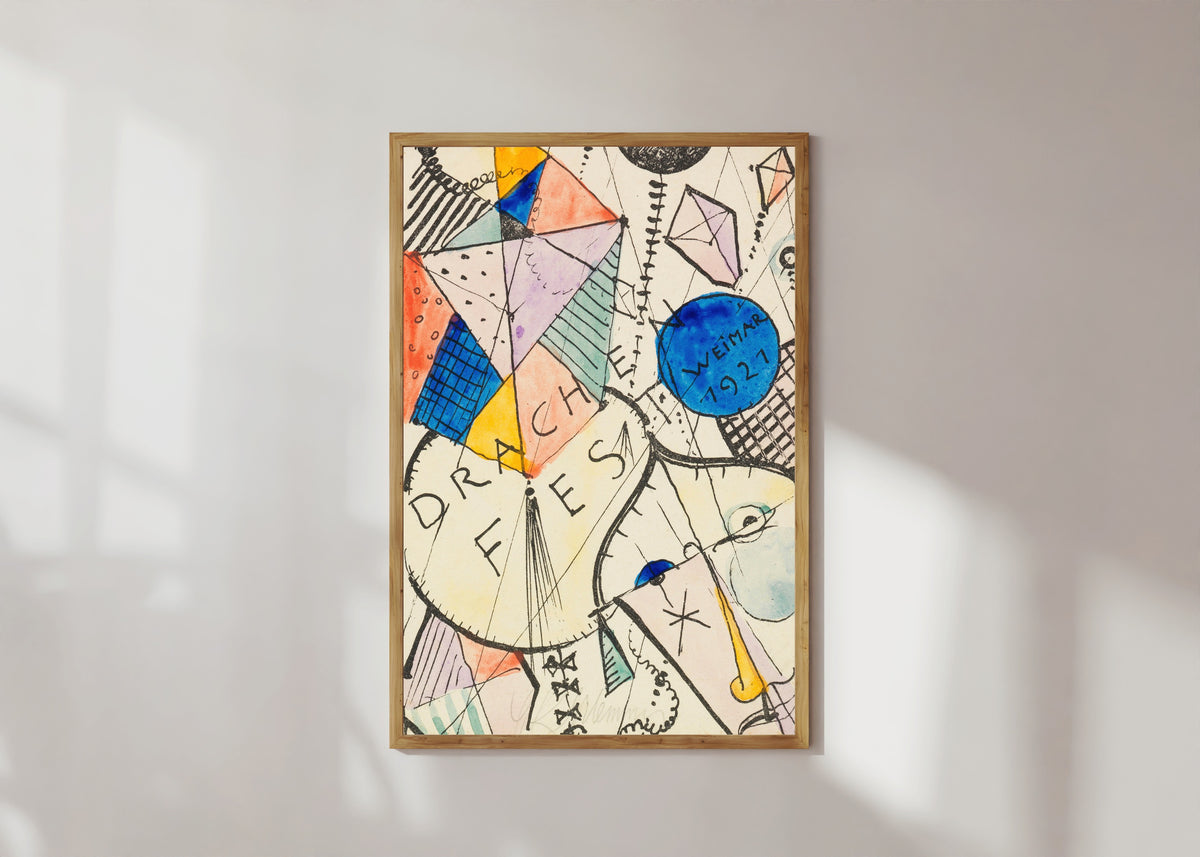 Framed art print of Drachenfest by Oskar Schlemmer, in a light wood frame on a sunlit white wall