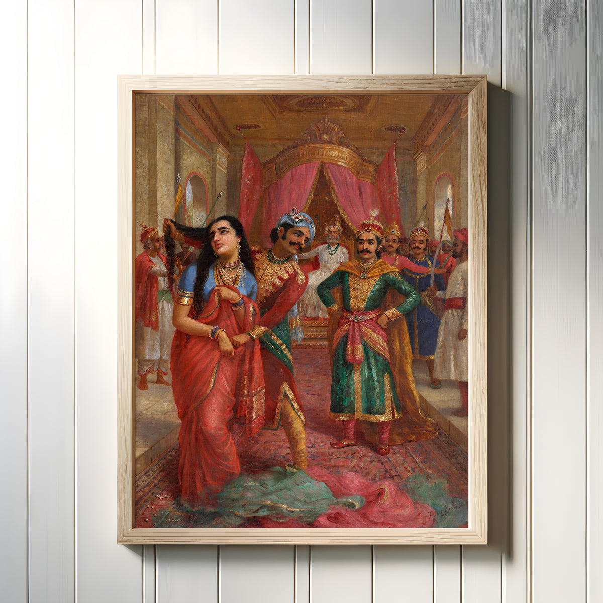 Framed art print of Draupadi Vastraharan by Raja Ravi Varma, in a light wood frame on a white panelled wall