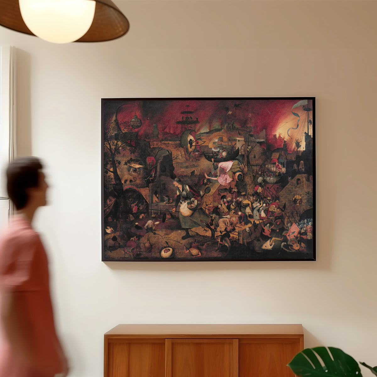 Framed art print of Dulle Griet by Pieter Bruegel the Elder, in a slim black frame on a warm wall in a sunlit room