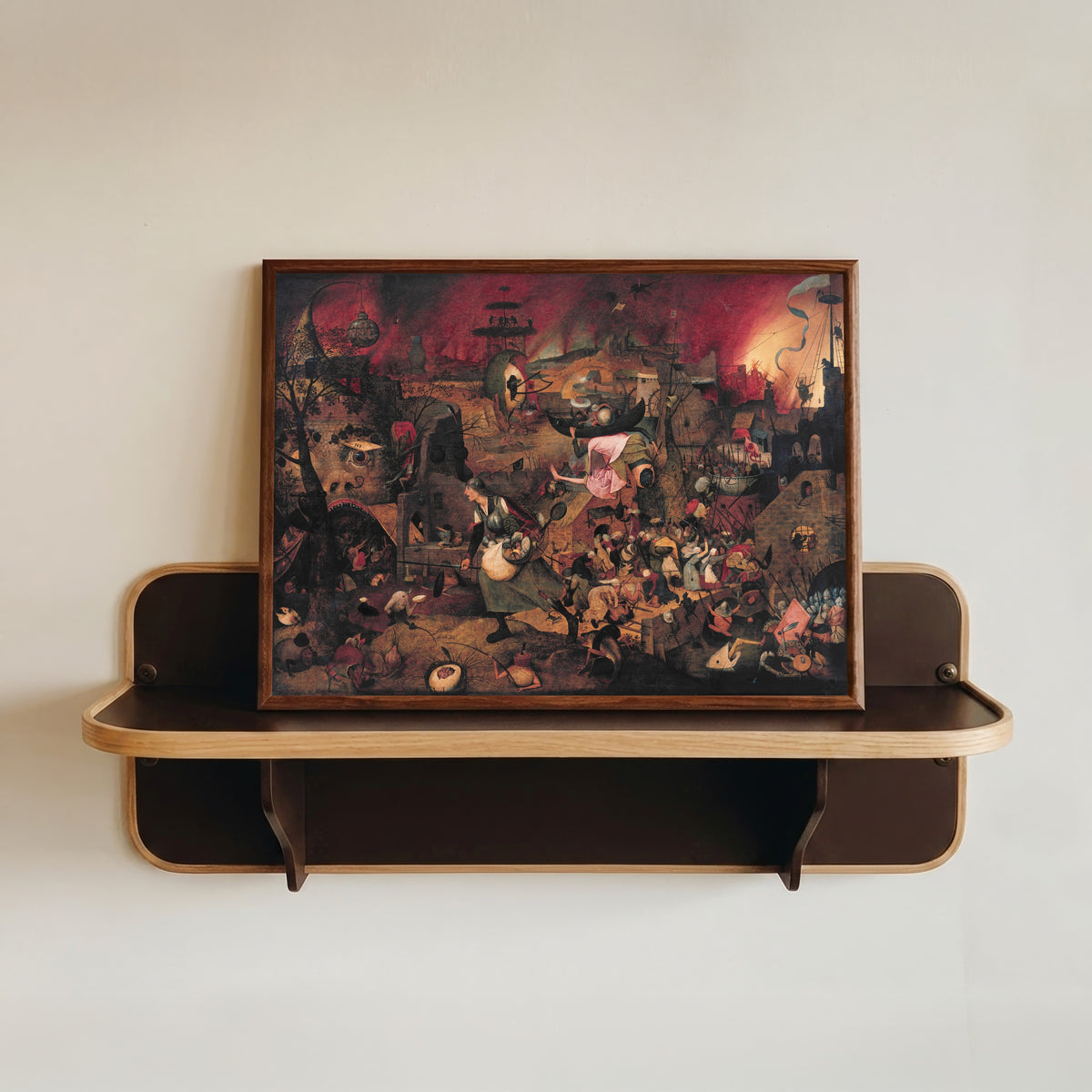 Framed art print of Dulle Griet by Pieter Bruegel the Elder, in a dark wood frame resting on a wall shelf