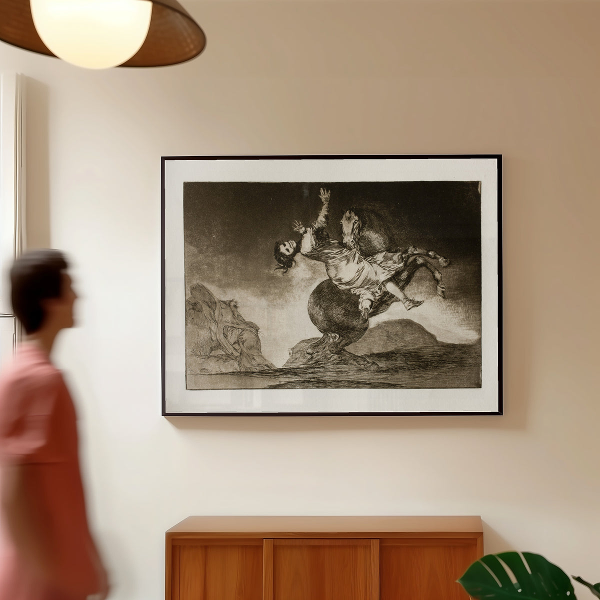 Framed art print of El caballo raptor (The Horse Abductor), from Los Disparates by Francisco de Goya, in a slim black frame on a warm wall in a sunlit room