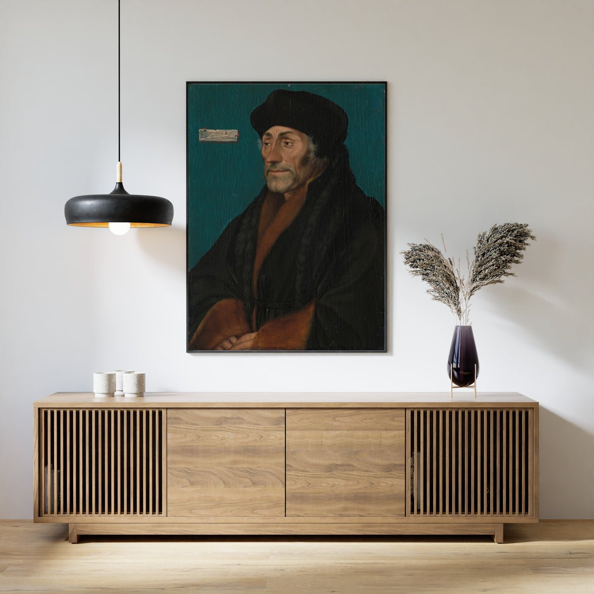 Framed art print of Erasmus of Rotterdam by Hans Holbein the Younger, above a slatted wood sideboard