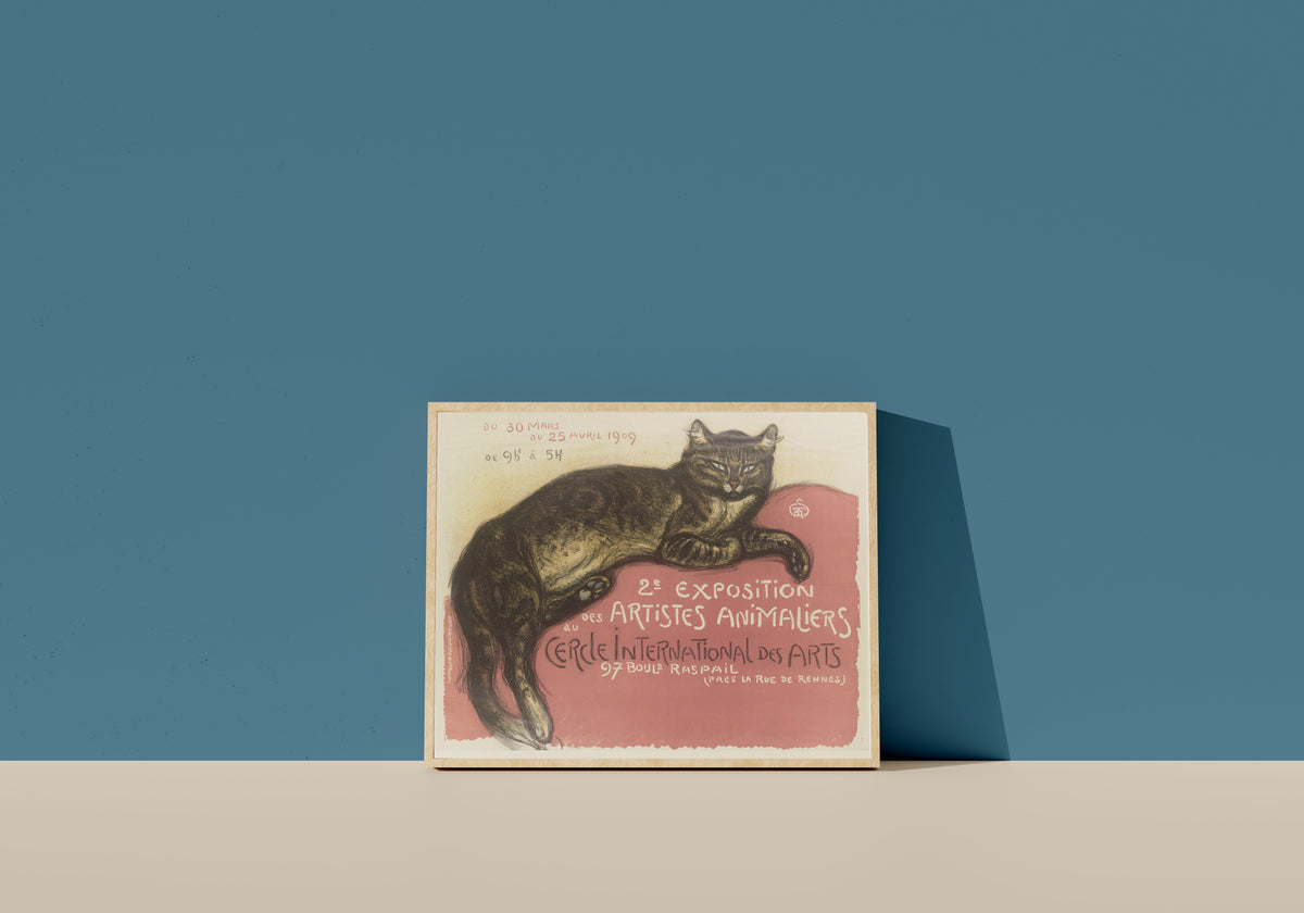 Framed art print of Exposition des artistes animaliers au Cercle International des Arts by Théophile Steinlen, in a light wood frame leaning on a blue wall
