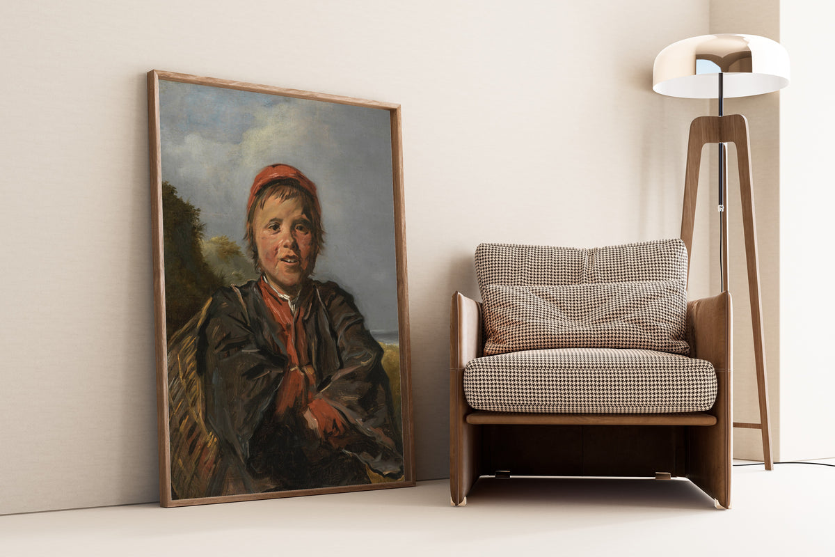Framed art print of Fisherboy by Frans Hals, leaning against a wall beside an armchair and a floor lamp