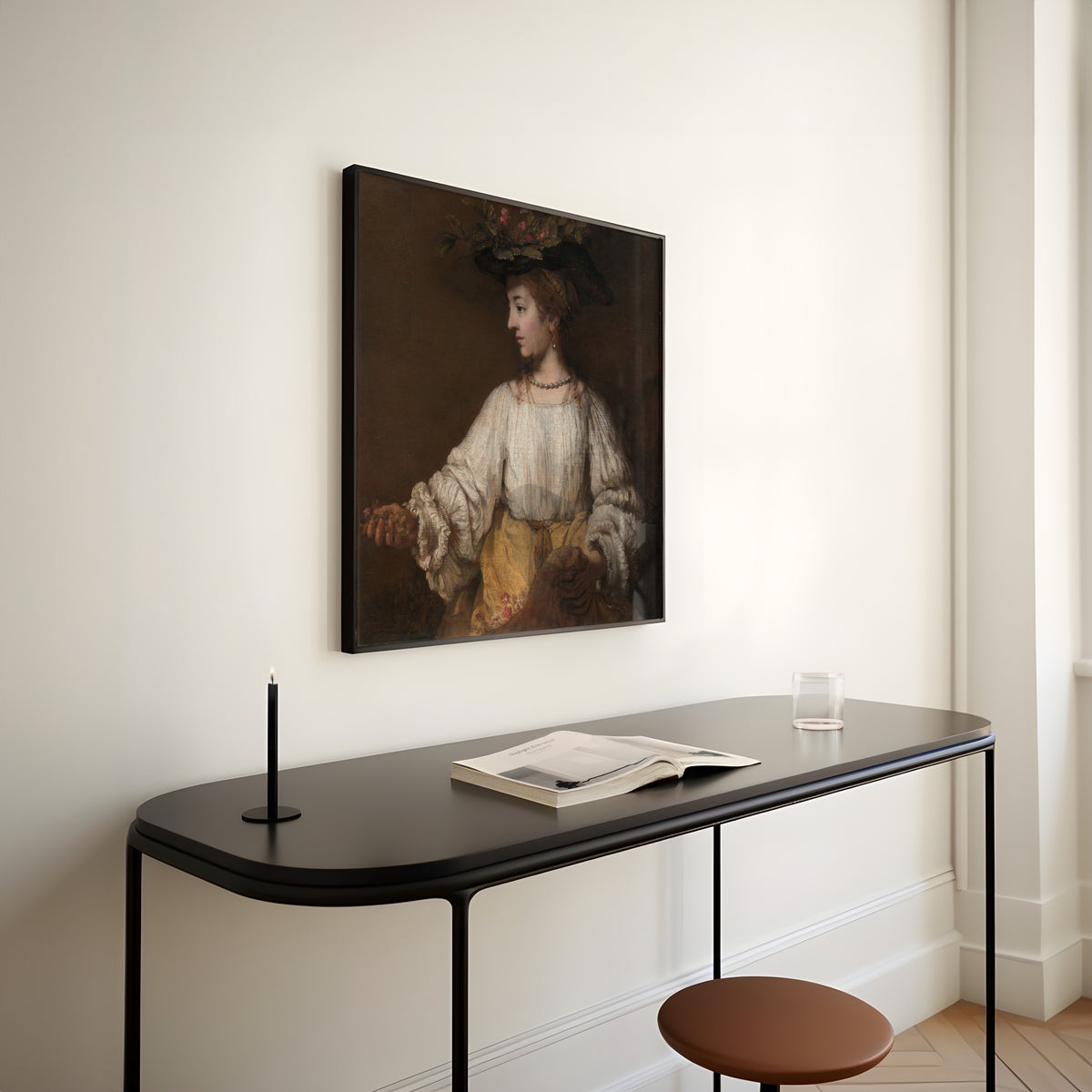 Framed art print of Flora by Rembrandt van Rijn, above a slim black console table