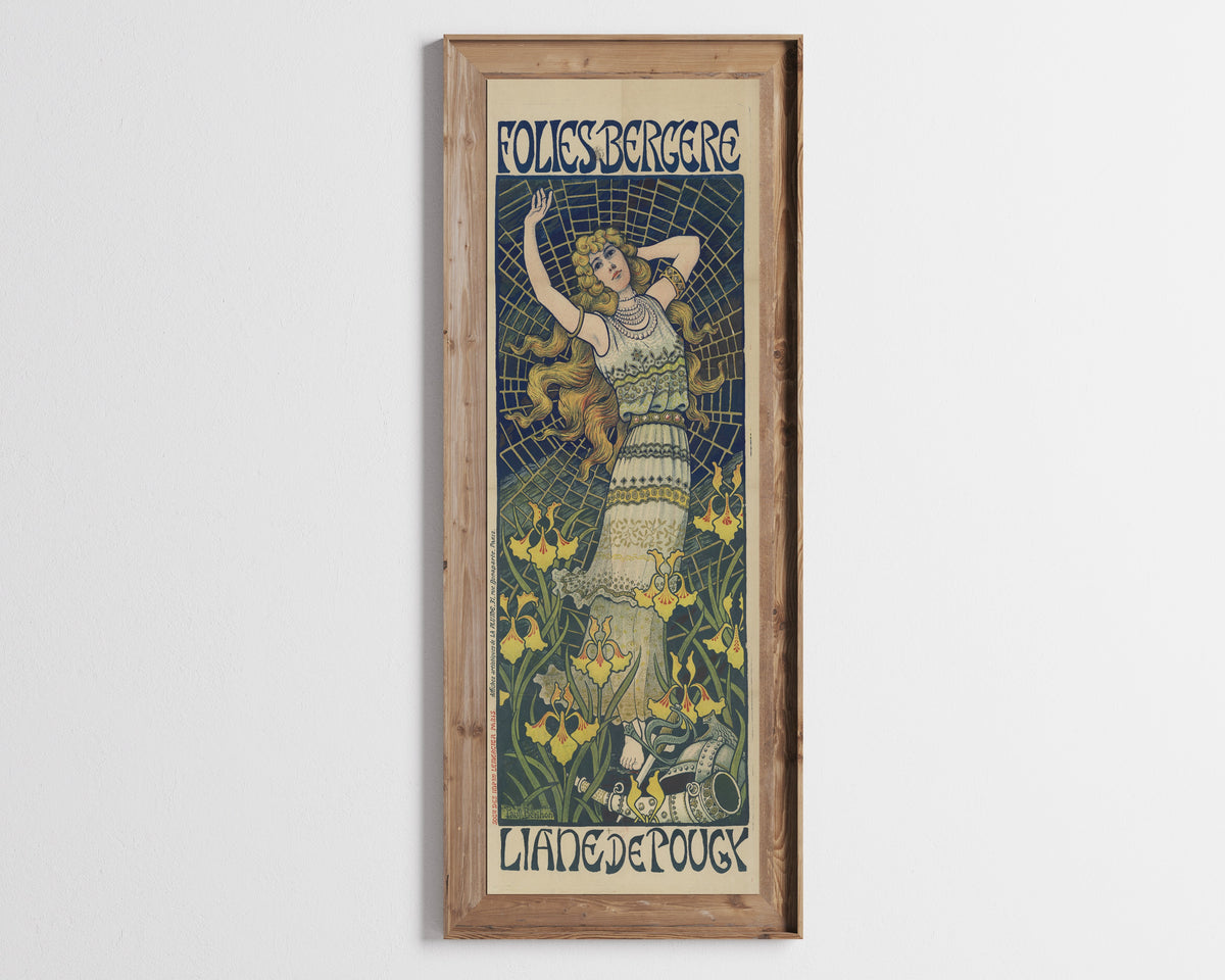 Framed art print of Folies Bergère: Liane de Pougy by Paul Berthon, in a tall wooden frame on a pale wall