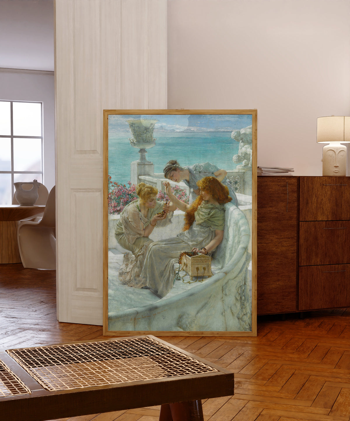 Framed art print of Fortune's Favourite by Lawrence Alma-Tadema, in a light wood frame leaning in a warm room with a parquet floor