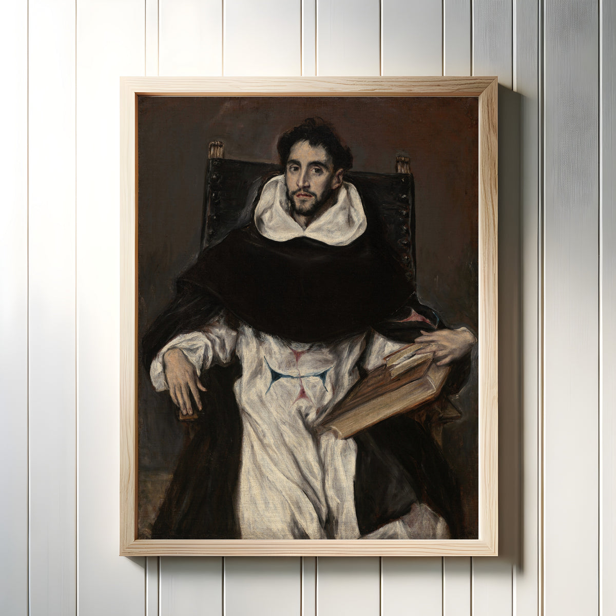 Framed art print of Fray Hortensio Félix Paravicino by El Greco, in a light wood frame on a white panelled wall