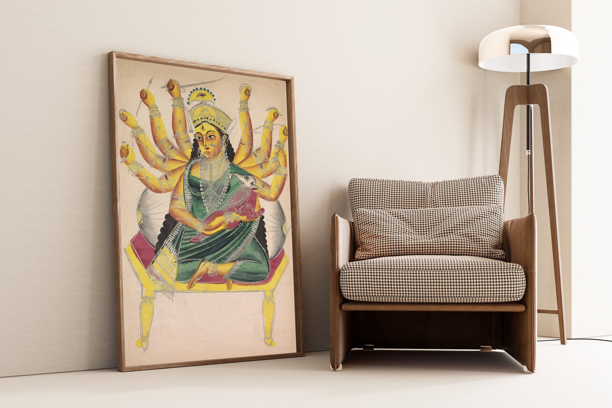 Framed art print of Ganesha-Janani (Mother of Ganesh) by Kalighat painter, leaning against a wall beside an armchair and a floor lamp