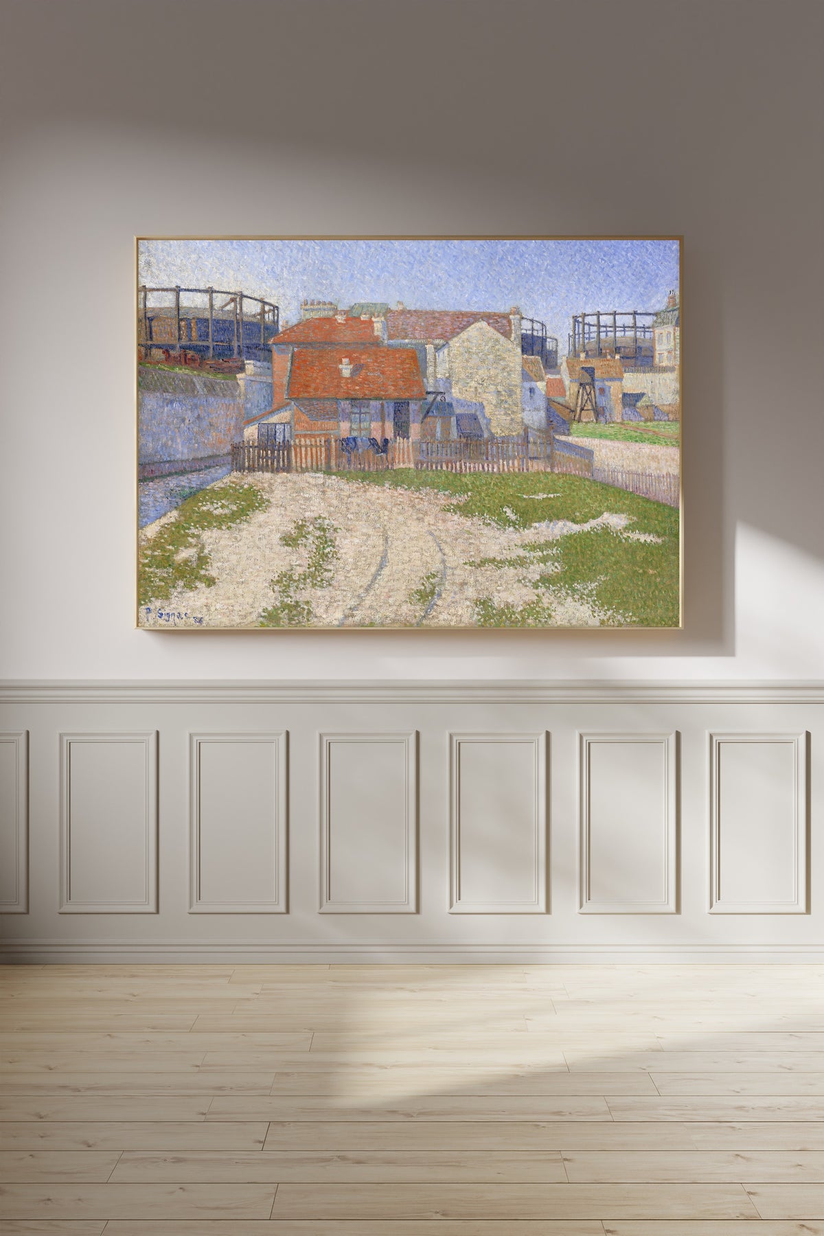 Framed art print of Gasometers at Clichy by Paul Signac, on a panelled wall in afternoon light