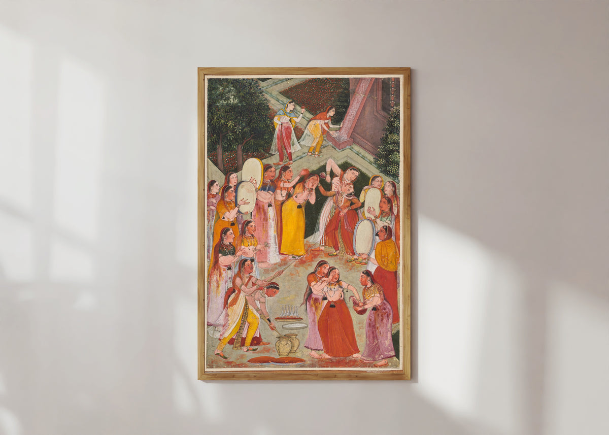 Framed art print of Girls Spraying Each Other at Holi by Bikaner school, in a light wood frame on a sunlit white wall
