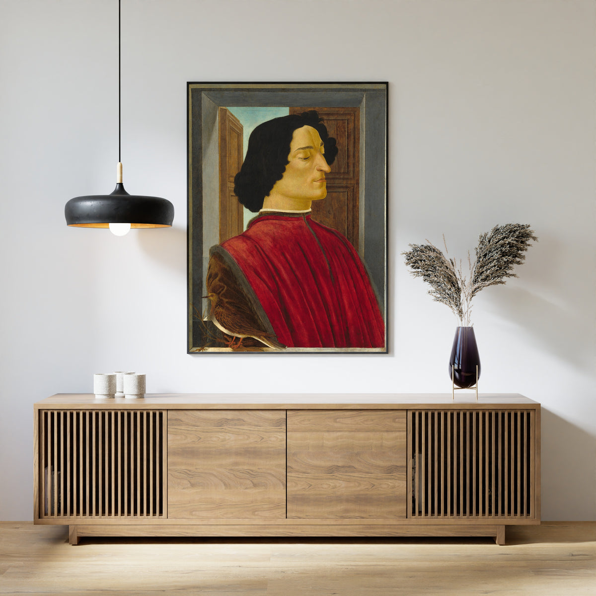 Framed art print of Giuliano de’ Medici by Sandro Botticelli, above a slatted wood sideboard