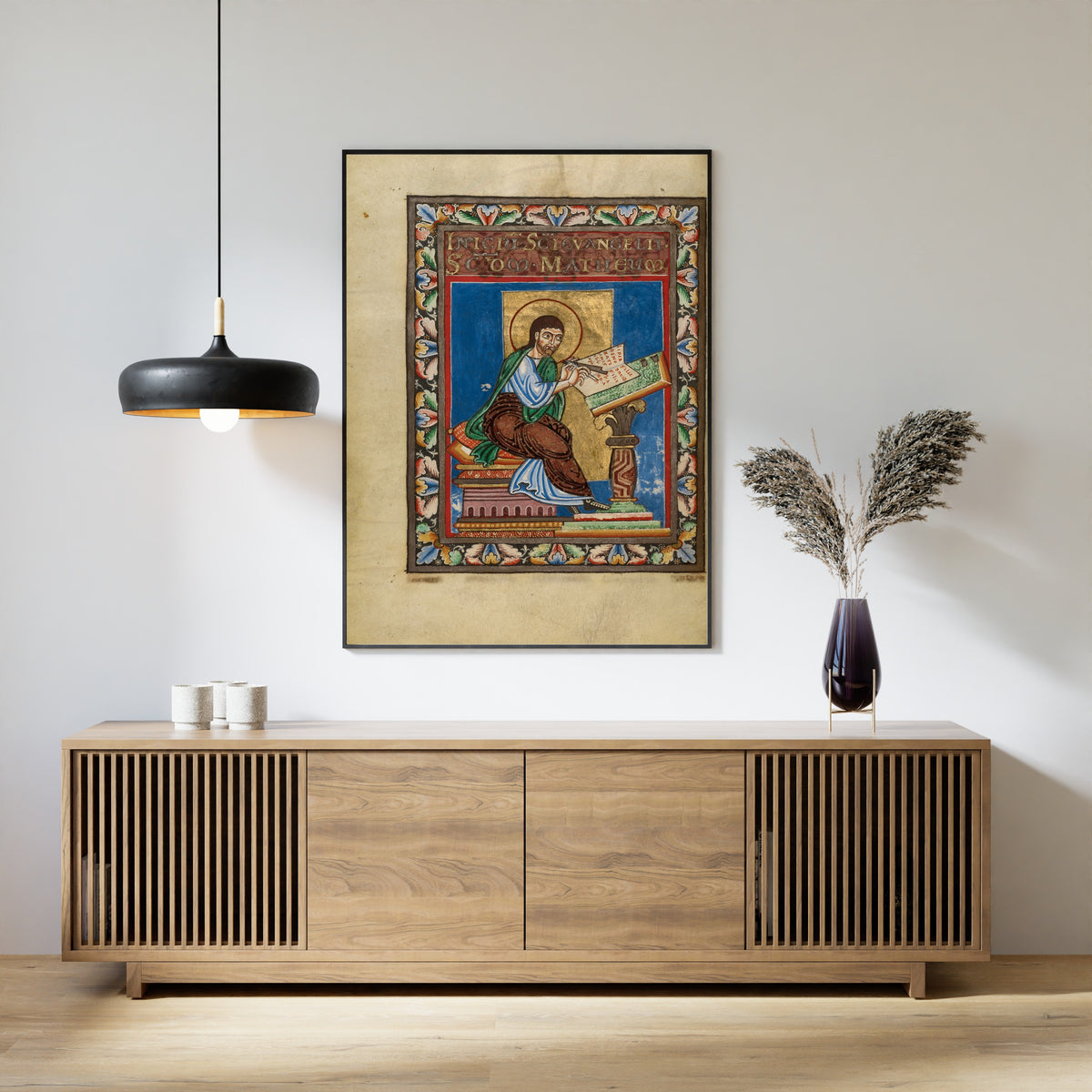 Framed art print of Gospel Book: Saint Matthew, above a slatted wood sideboard