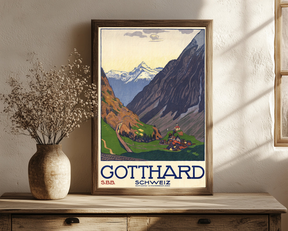 Framed art print of Gotthard Schweiz by Emil Cardinaux, in a dark wood frame leaning on a rustic console beside dried flowers