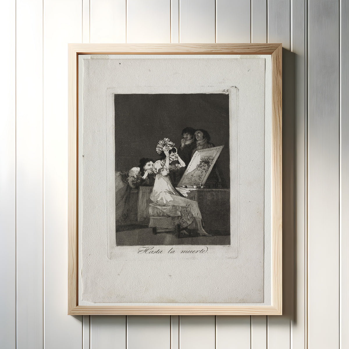 Framed art print of Hasta la muerte (Until Death), Los Caprichos, Plate 55 by Francisco de Goya, in a light wood frame on a white panelled wall