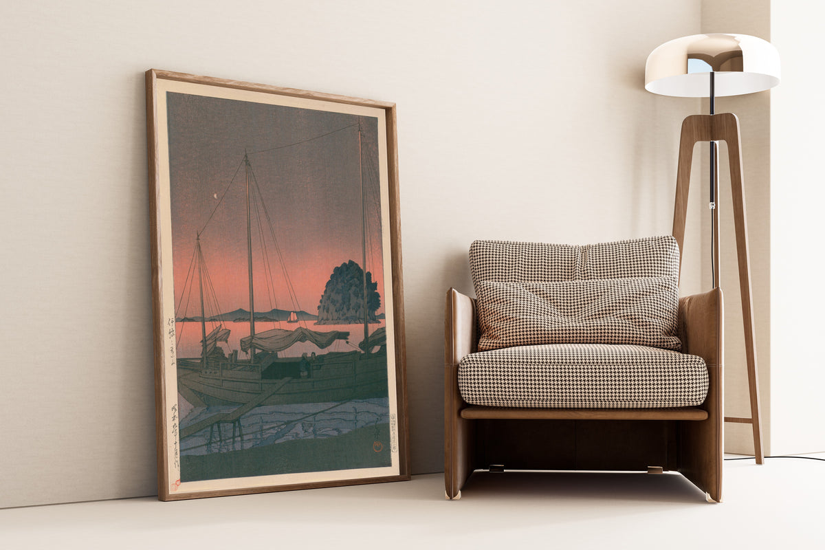 Framed art print of Hayama in Iyo by Kawase Hasui, leaning against a wall beside an armchair and a floor lamp