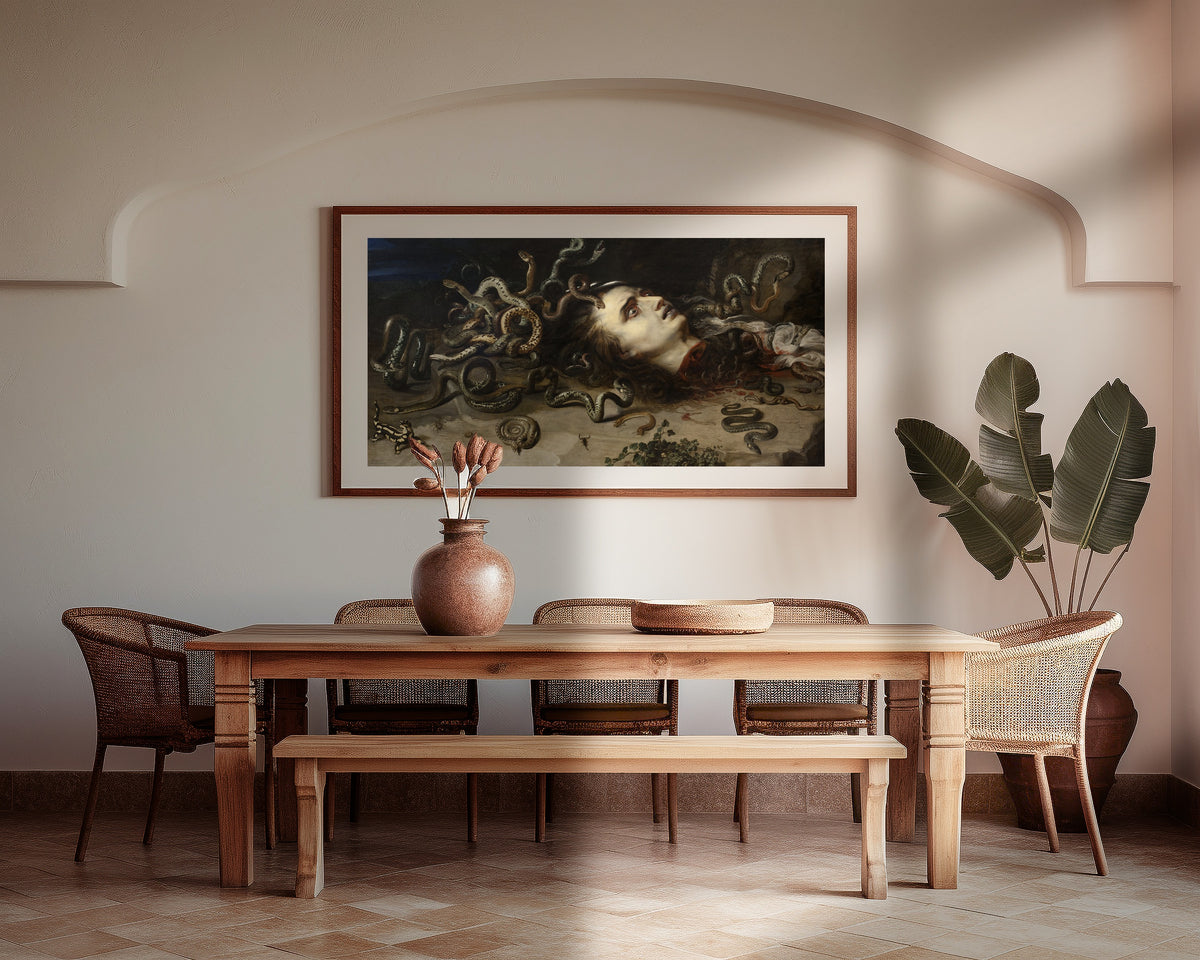 Framed art print of Head of Medusa by Peter Paul Rubens, above a wooden dining table