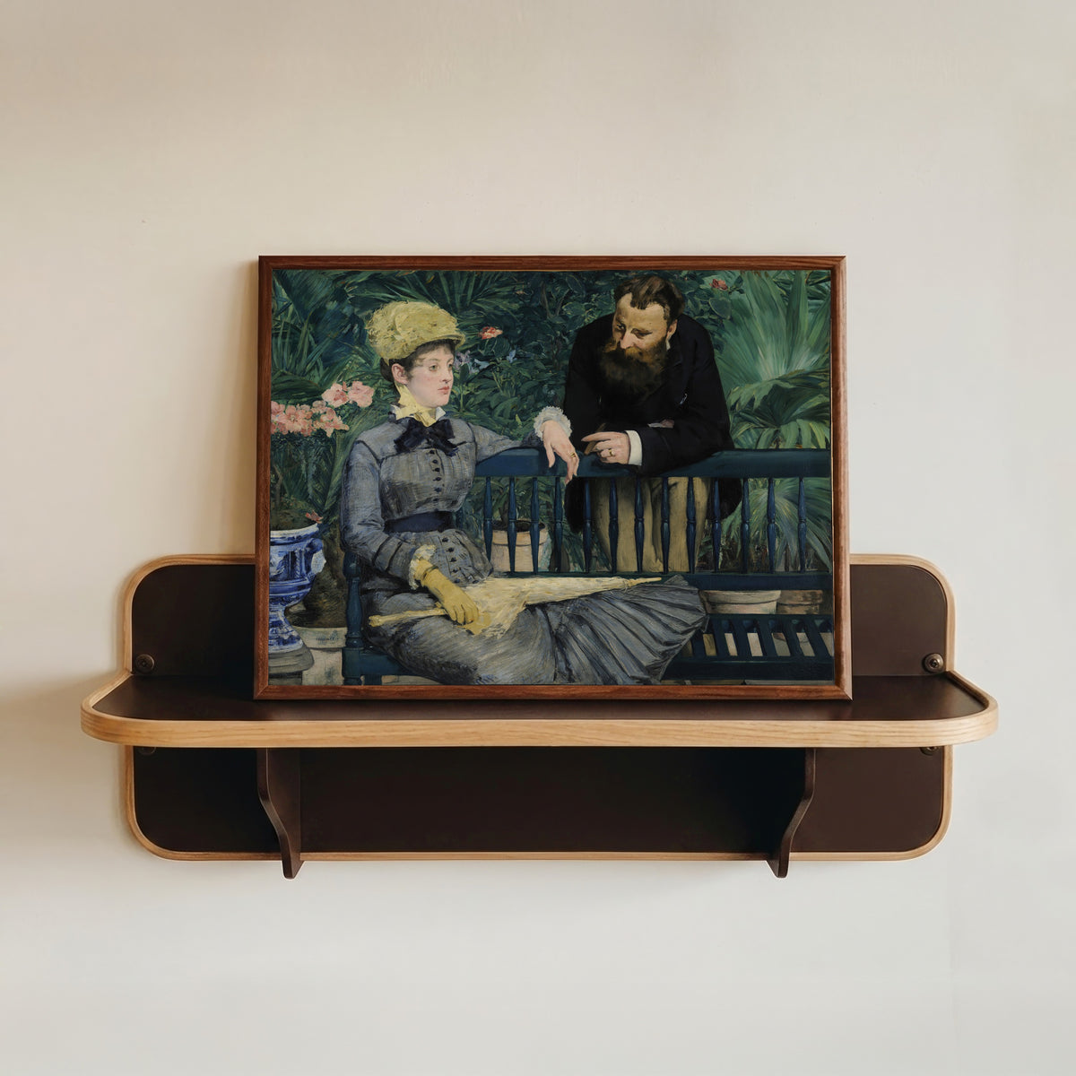 Framed art print of In the Conservatory by Édouard Manet, in a dark wood frame resting on a wall shelf