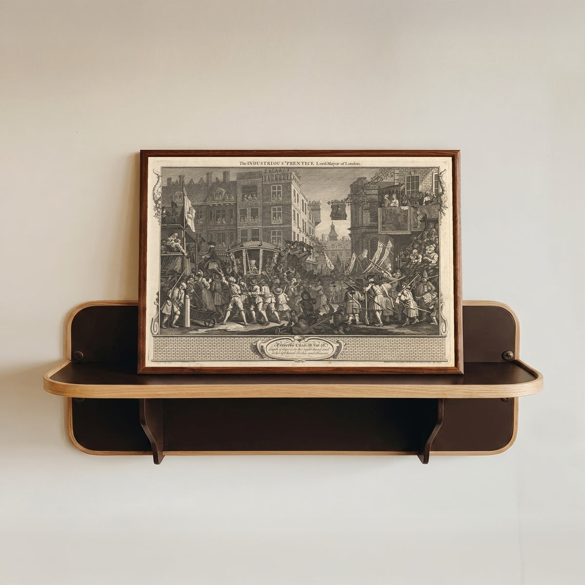 Framed art print of Industry and Idleness, Plate 12: The Industrious 'Prentice Lord Mayor of… by William Hogarth, in a dark wood frame resting on a wall shelf