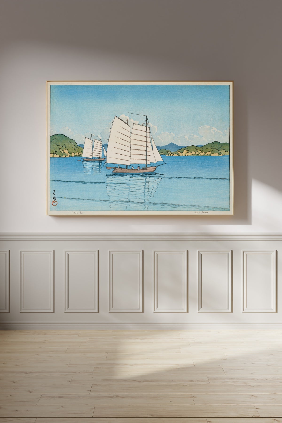 Framed art print of Inland Sea by Kawase Hasui, on a panelled wall in afternoon light