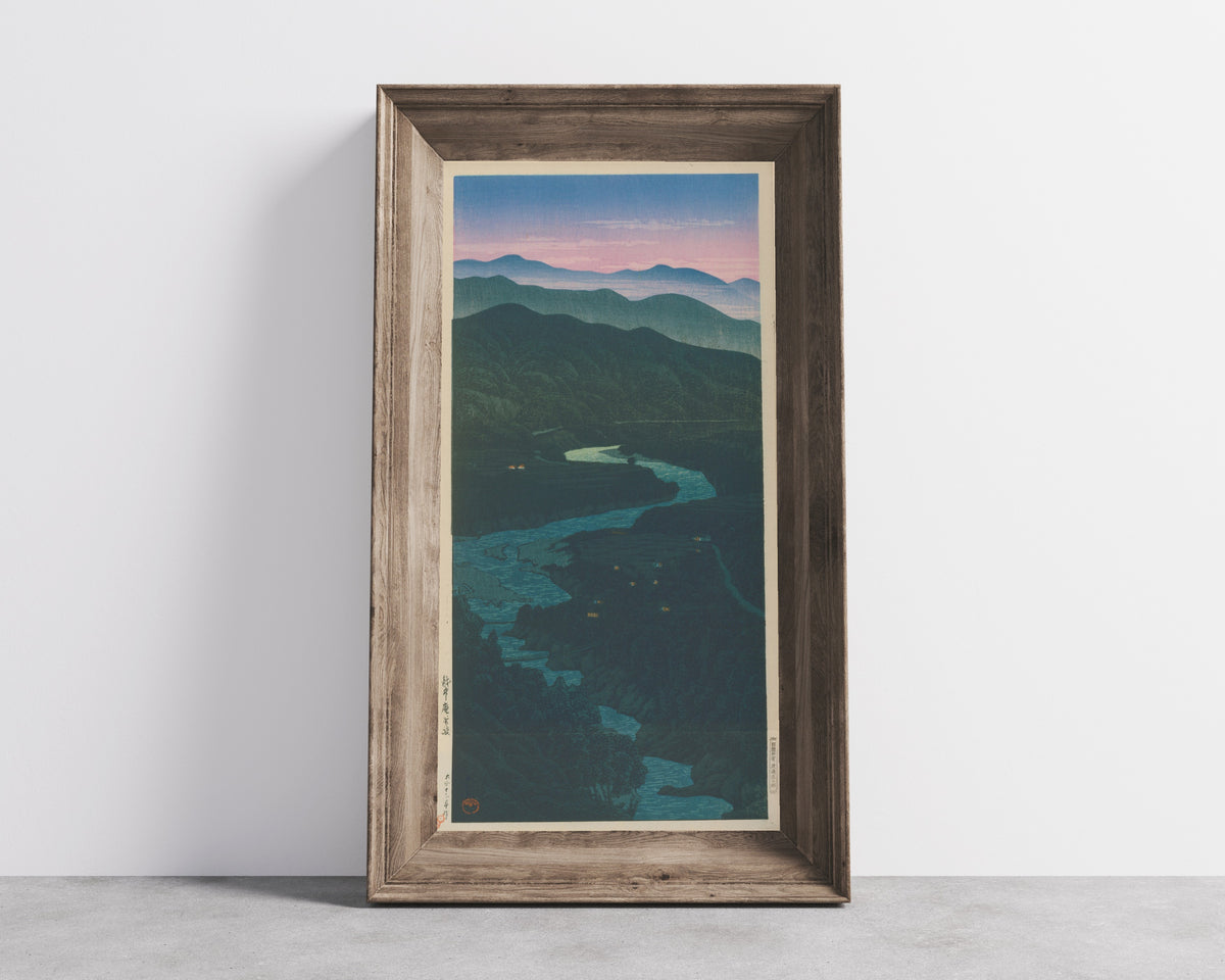 Framed art print of Ioridani Pass, Etchu by Kawase Hasui, in a wide wooden frame leaning against a concrete wall