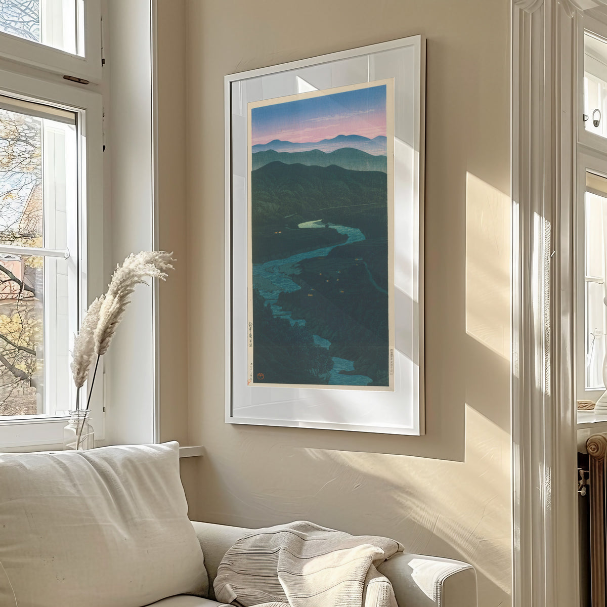 Framed art print of Ioridani Pass, Etchu by Kawase Hasui, in a sunlit living room above a sofa