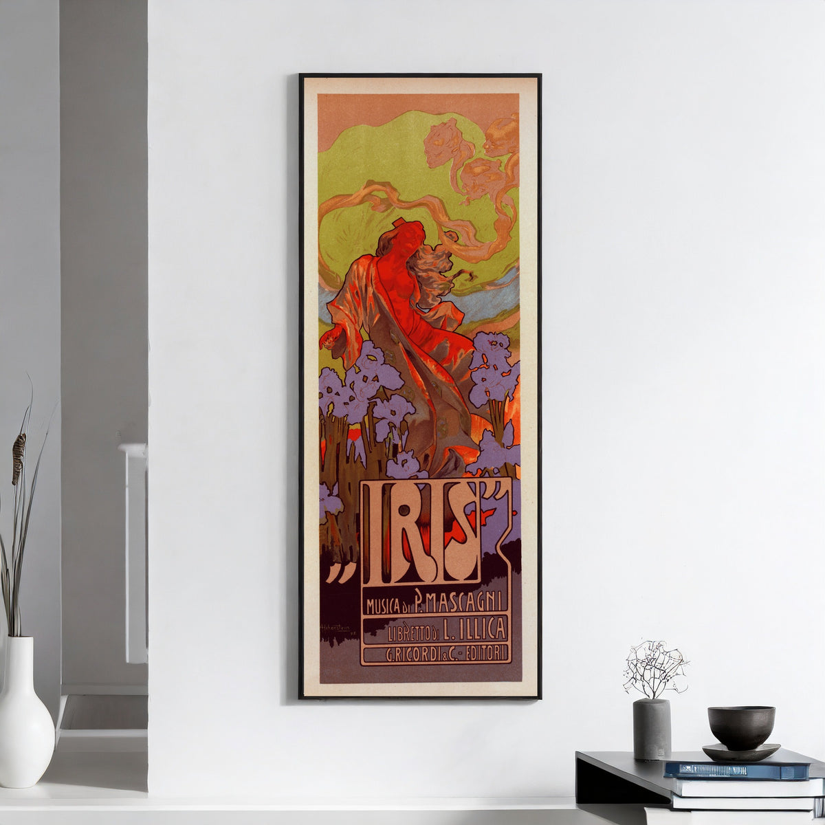 Framed art print of Iris by Adolfo Hohenstein, on a white wall above books and a bowl