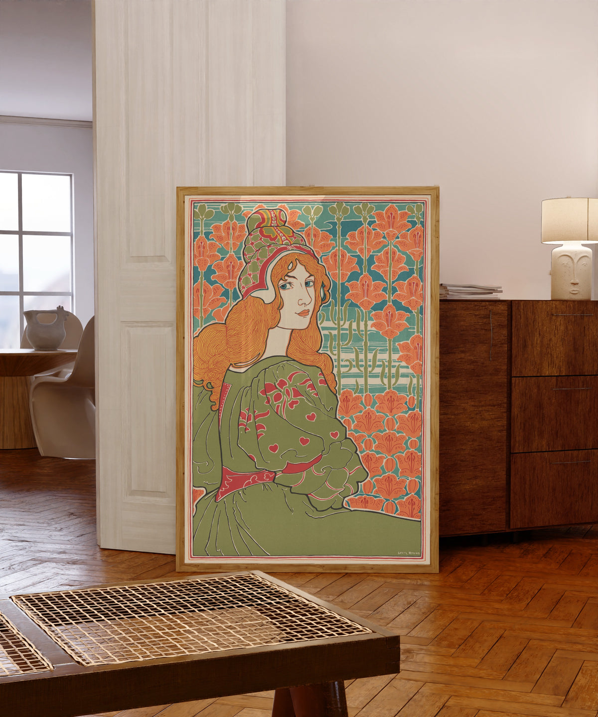 Framed art print of Jane by Louis Rhead, in a light wood frame leaning in a warm room with a parquet floor