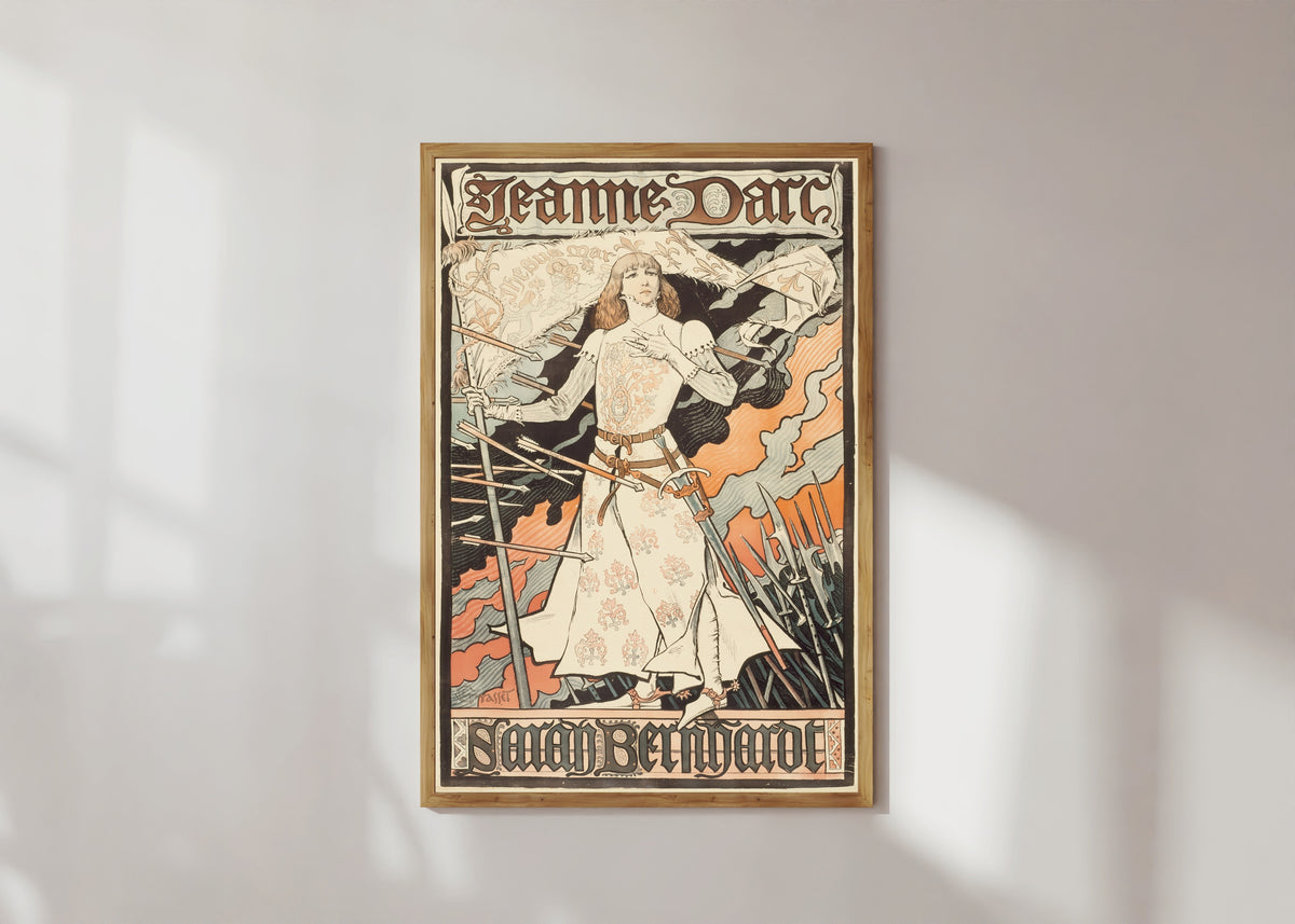 Framed art print of Jeanne d'Arc-Sarah Bernhardt by Eugène Grasset, in a light wood frame on a sunlit white wall