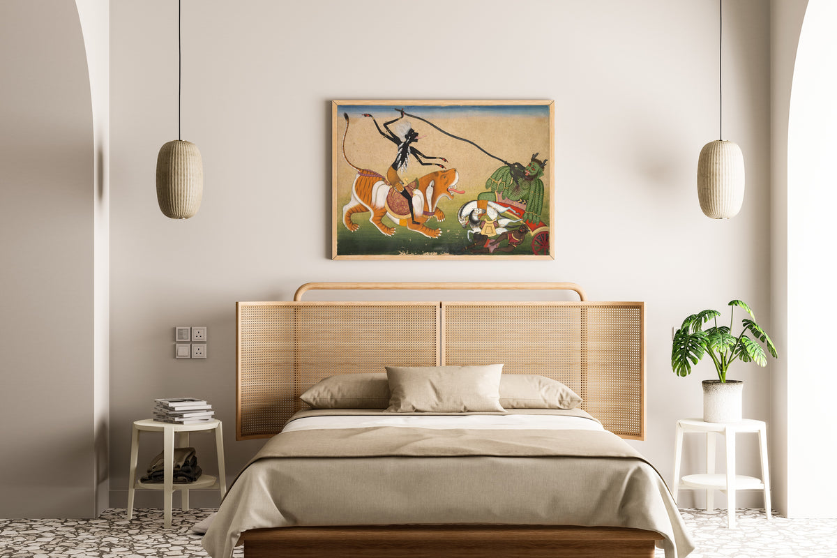 Framed art print of Kali Attacking Nisumbha by Pahari school, above a cane-headboard bed