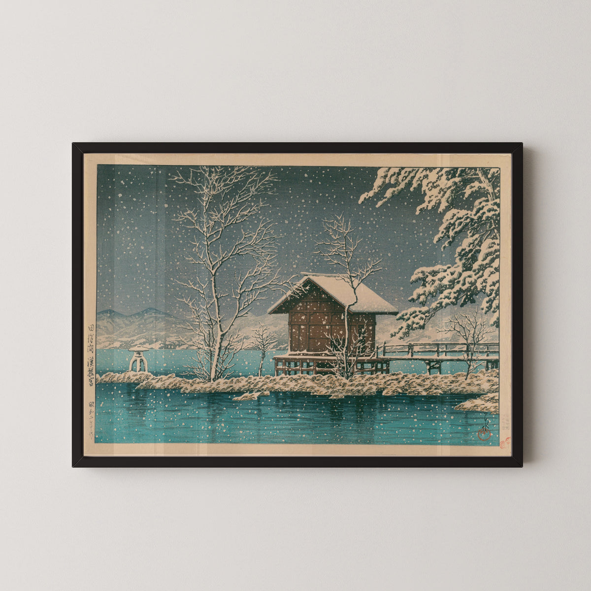 Framed art print of Kansanomiya Shrine at Lake Tazawa by Kawase Hasui, in a black frame on a pale wall