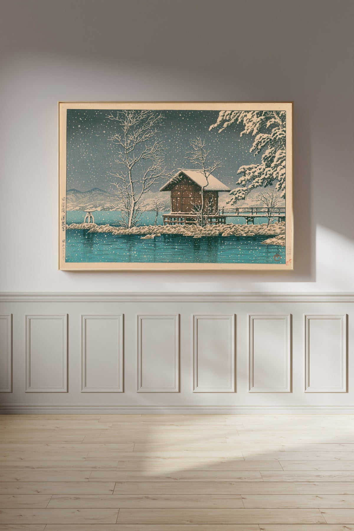 Framed art print of Kansanomiya Shrine at Lake Tazawa by Kawase Hasui, on a panelled wall in afternoon light