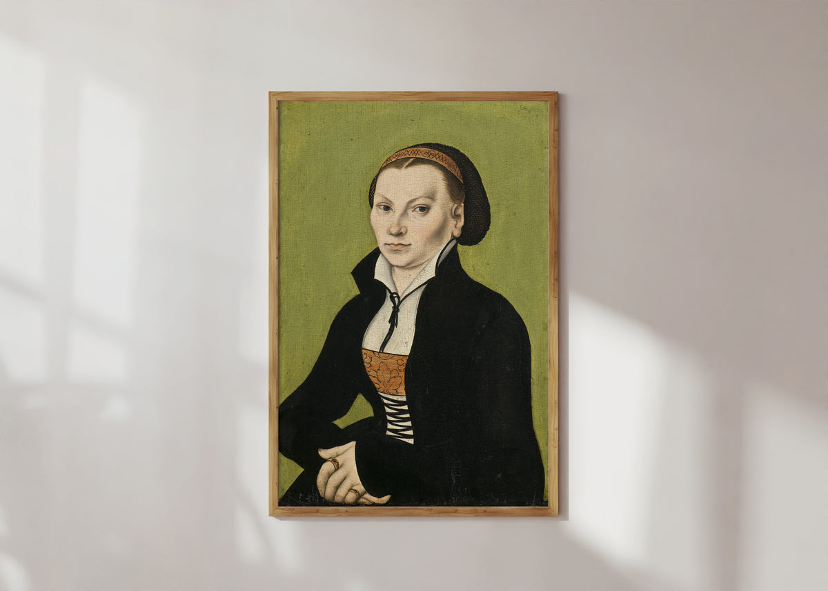 Framed art print of Katharina von Bora, Wife of Martin Luther by Lucas Cranach the Elder, in a light wood frame on a sunlit white wall