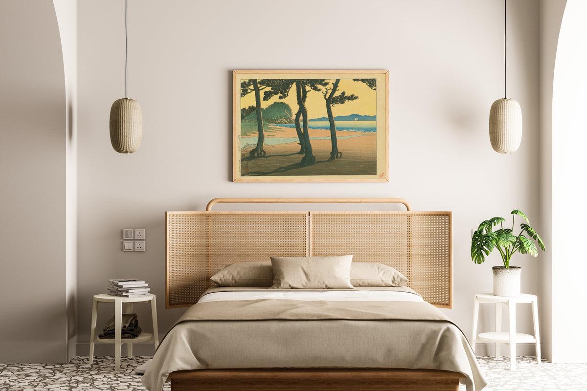 Framed art print of Kazusa Beach in Hizen Province by Kawase Hasui, above a cane-headboard bed